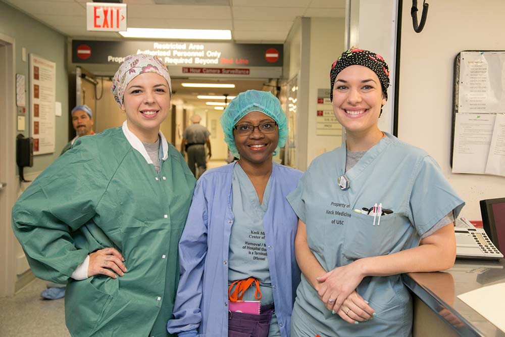 Smiling nurses in a hallway.